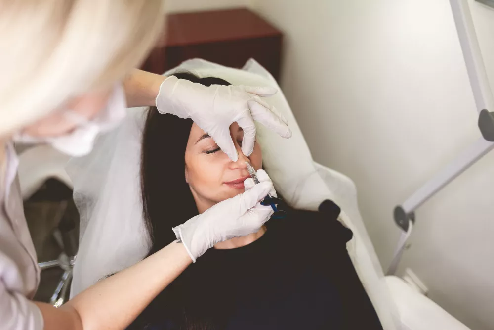 Aesthetic practitioner injecting dermal filler into a patient's nose during non-surgical rhinoplasty at Navaa, Mumbai